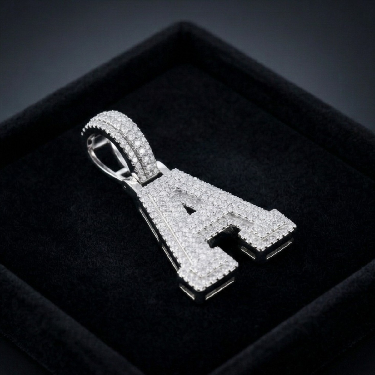 Silver letter 'A' pendant with diamonds on a dark background