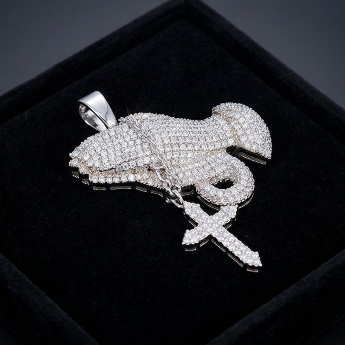 Silver lobster-shaped pendant with clear stones on a black velvet background