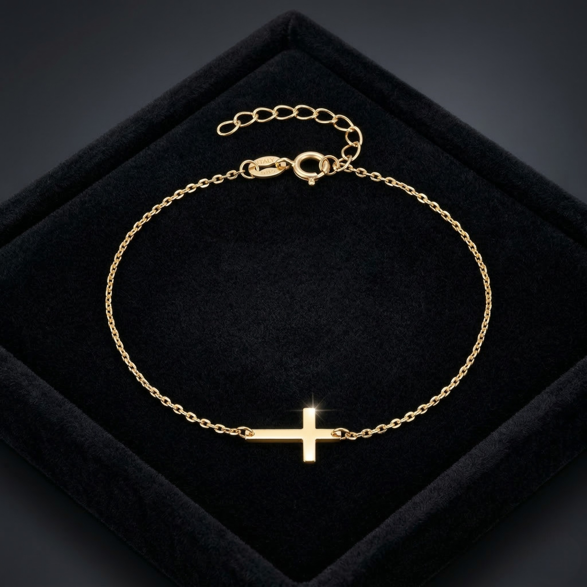Gold bracelet with a cross on a black velvet surface