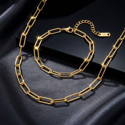 Gold chain necklace on a dark fabric background