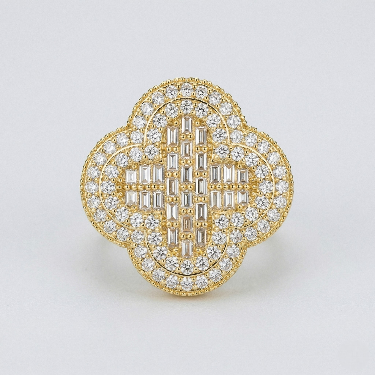 Gold and diamond brooch on a light gray background