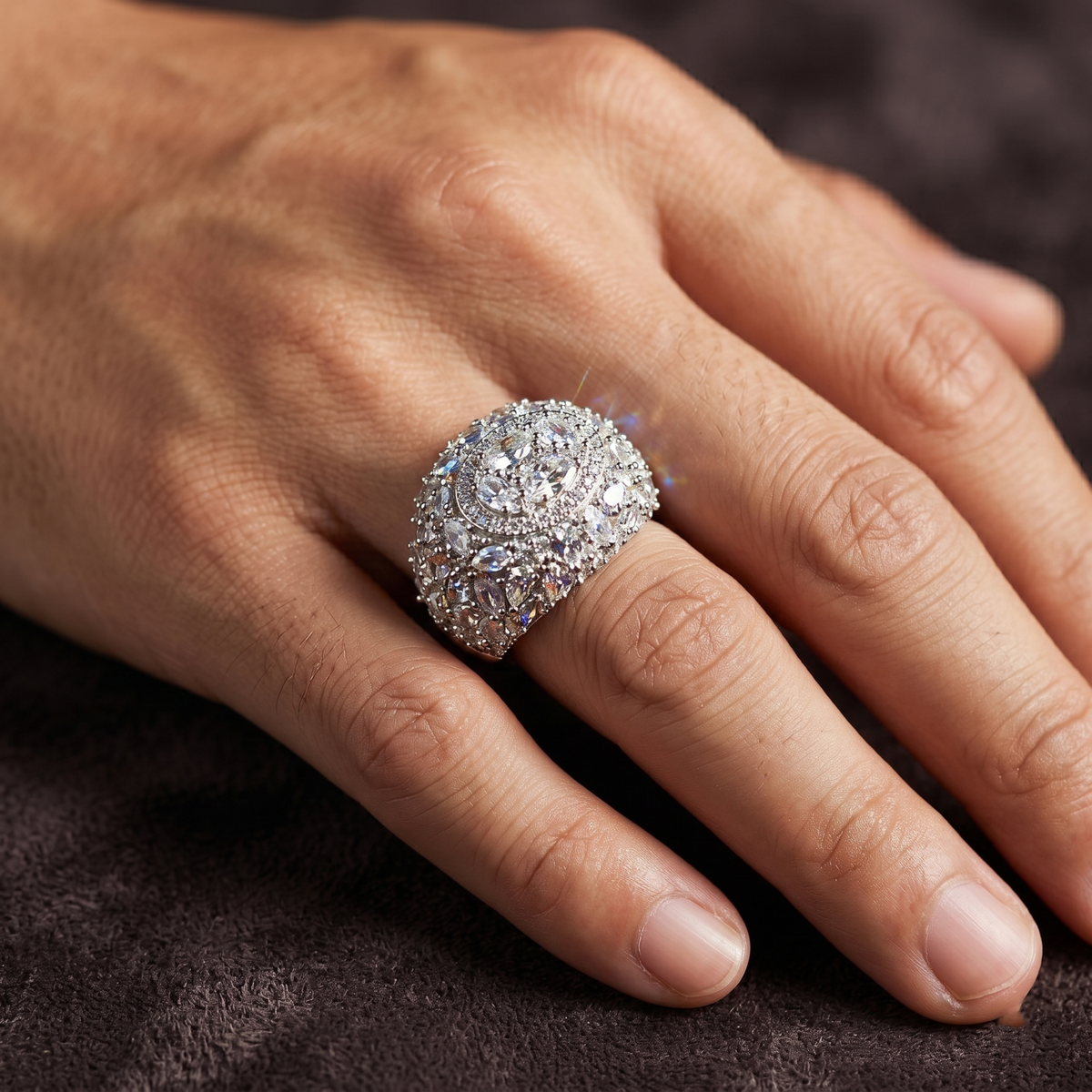 Close-up of a hand wearing a sparkling diamond ring on a dark fabric background