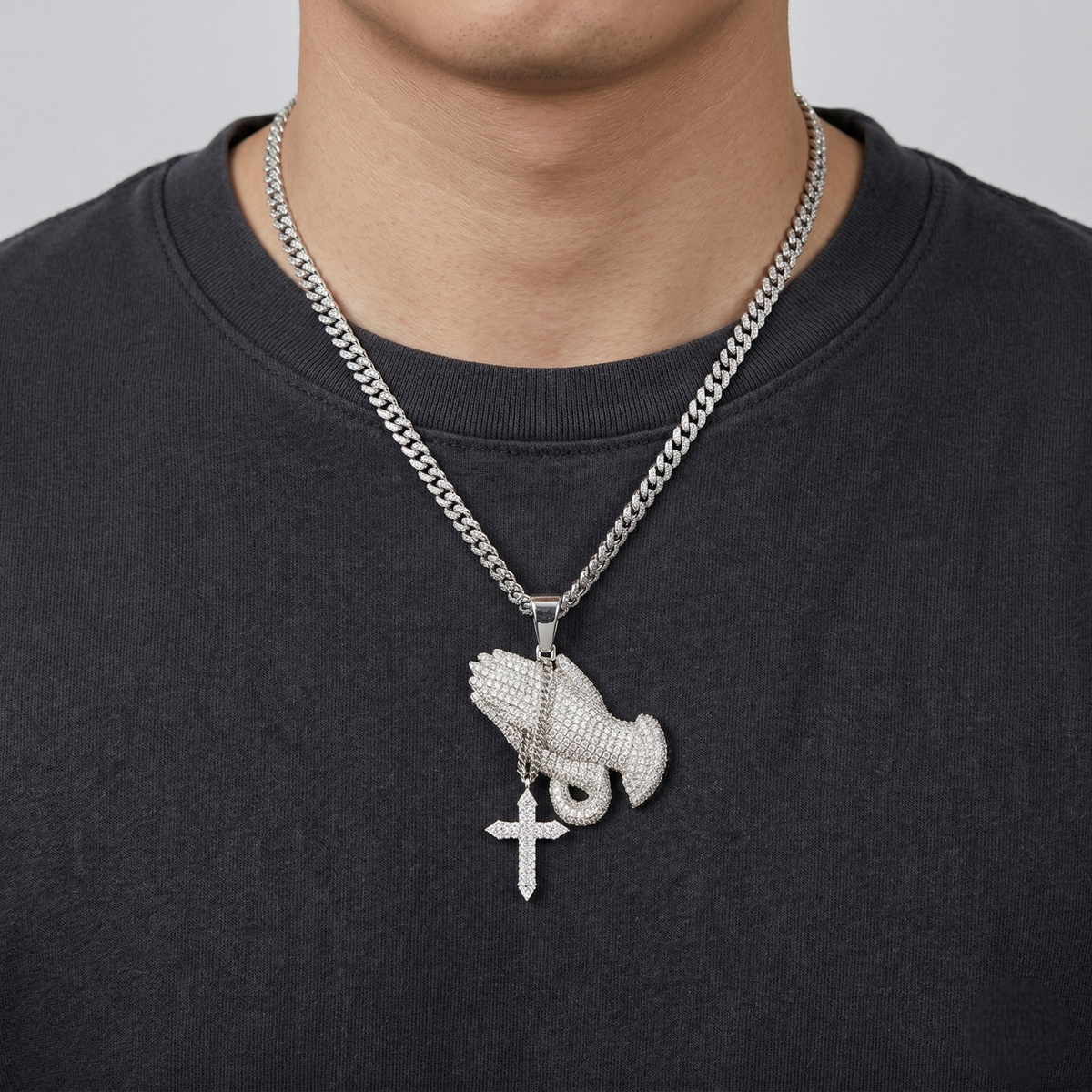 Necklace with a pendant featuring a cross and another design on a black shirt.