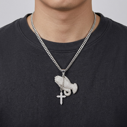 Necklace with a pendant featuring a cross and another design on a black shirt.
