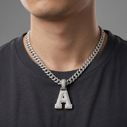 Man wearing a silver chain necklace with an 'A' pendant on a gray background