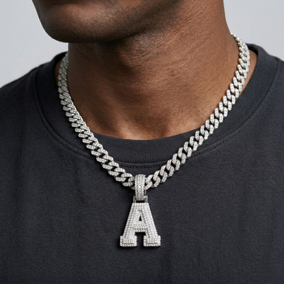 Person wearing a silver chain necklace with an 'A' pendant on a plain background