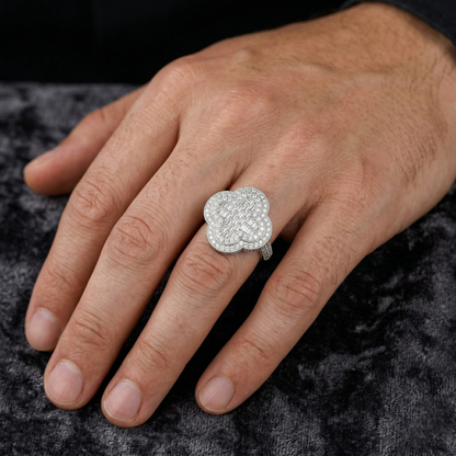 Close-up of a hand wearing a silver ring with a diamond design on a dark textured background