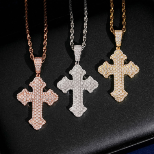 Three cross-shaped pendants on chains against a dark background