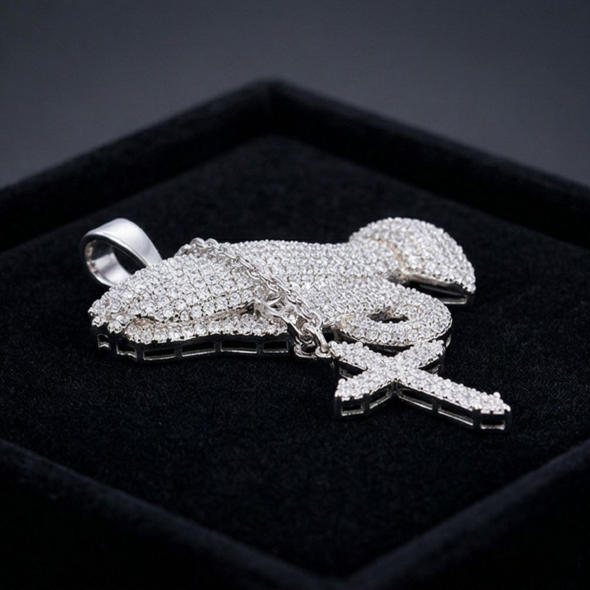 Silver lobster-shaped pendant with clear stones on a black background