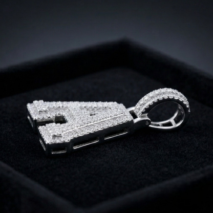 Silver letter pendant with gemstones on a dark background