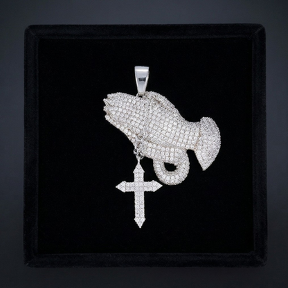 Silver pendant with fish and cross design on a black velvet background