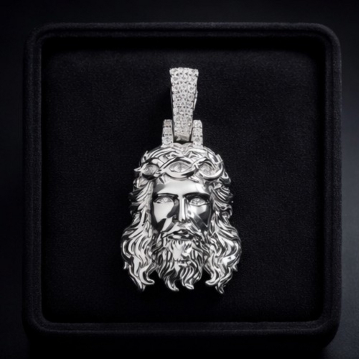 Silver pendant of a bearded figure with a crown of thorns on a black background