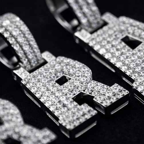 Close-up of a diamond-encrusted pendant with letters on a dark background